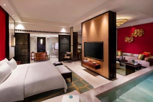 a bedroom with a large bed and a living room at Banyan Tree Macau in Macau