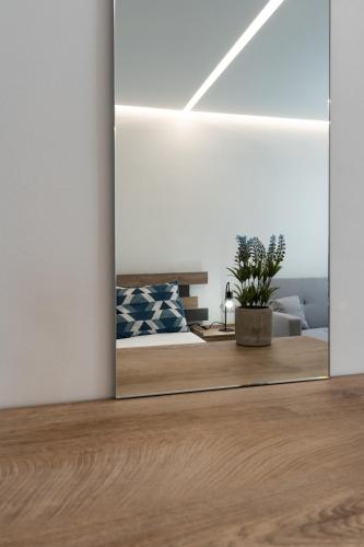 a mirror in a room with a bed and a couch at POUNEDES LUXURY SUITES in Pefki Rhodes