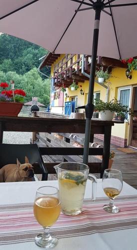 a table with two glasses of drinks on a table with a dog at American Dream in Şimon