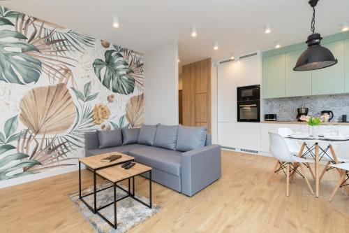 a living room with a couch and a table and a kitchen at Garden Gates Apartments by Renters in Gdańsk