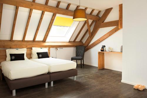 1 dormitorio con 2 camas y ventana en Hoevehotel 'Hof Christina' en Vrouwenpolder