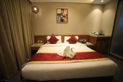a bedroom with a bed with two cats sitting on it at The Byke Delotel in Mumbai