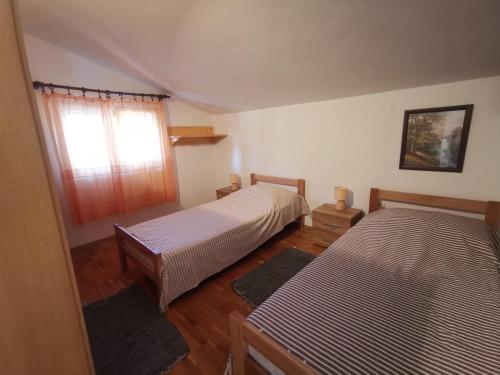 ein Schlafzimmer mit zwei Betten und einem Fenster in der Unterkunft Apartments Luca in Zaboric