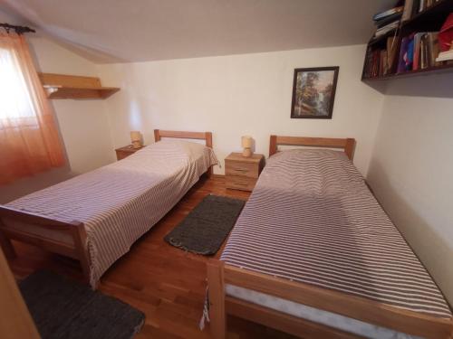 zwei Betten in einem Zimmer mit Holzboden in der Unterkunft Apartments Luca in Zaboric