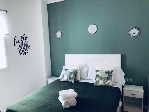 a bedroom with a green bed with towels on it at Sunlight Málaga Centro in Málaga