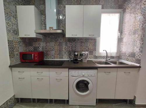 a kitchen with a washing machine and a sink at Sunlight Málaga Centro in Málaga