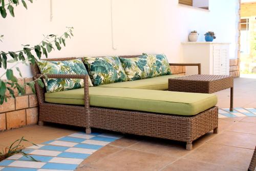 a wicker couch sitting on a patio at Casa Mia in Ouled Kacem