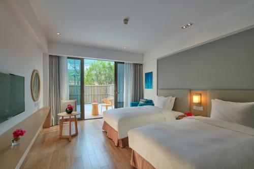 QingtianにあるHoliday Inn Express Zhejiang Qianxia Lake, an IHG Hotelのベッド2台と大きな窓が備わるホテルルームです。