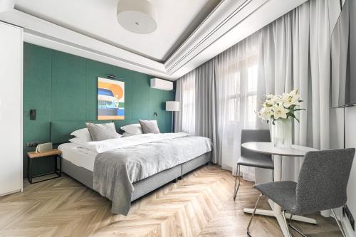 sypialnia z łóżkiem, stołem i krzesłami w obiekcie City Apartments - Apartamenty Butikowe w Koszalinie