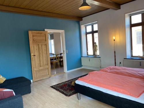 a bedroom with a bed and a door and a table at N1 Apartment in the heart of Højer in Højer
