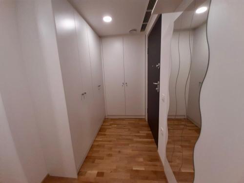 a room with white walls and a hallway with white cabinets at Diamond Bled in Bled