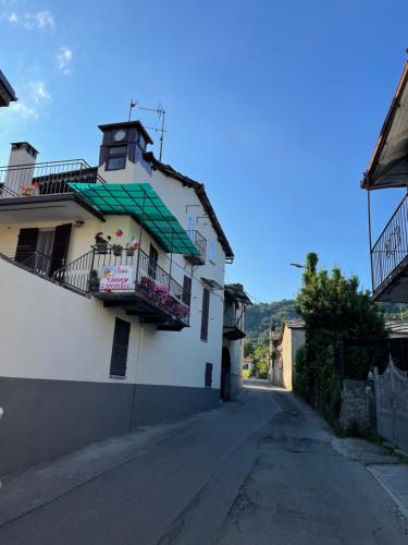 an empty street with a white building with a balcony at L'orologio panoramico in Luserna San Giovanni