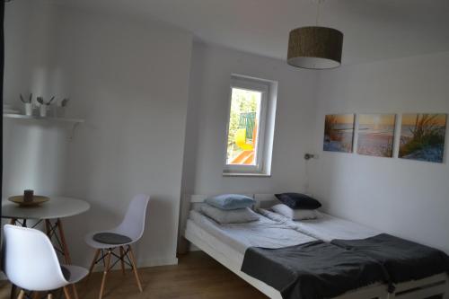 1 dormitorio con 1 cama, mesa y sillas en D.W Nawigator, en Ostrowo
