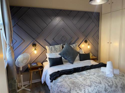 a bedroom with a large bed with a wooden headboard at Just Off Long - Inner City Gem in Cape Town