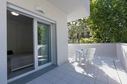 a patio with a table and chairs on a balcony at Residence Armony in Misano Adriatico