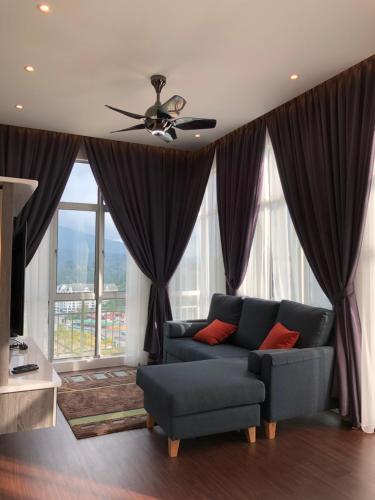 un soggiorno con divano e ventilatore a soffitto di Play Residence at Golden Hills a Cameron Highlands