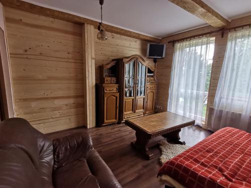 uma sala de estar com um sofá e uma mesa em Біла Хижа (Хата) em Verkhne-Studënyy