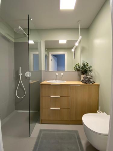 a bathroom with a toilet and a sink and a shower at Apartament Narcyzowa in Gdynia