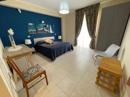 sypialnia z łóżkiem, stołem i krzesłem w obiekcie Agriturismo Villa Orchidea w mieście Ali Terme