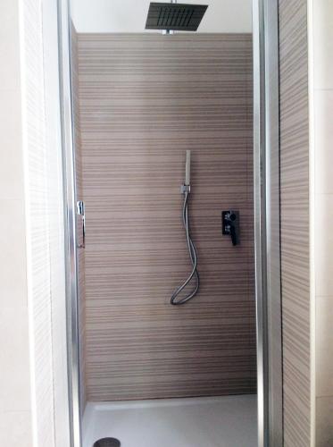 a shower with a hose attached to a wooden wall at Brevi vacanze a Brolo in Brolo