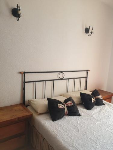 a bed with black pillows on top of it at CASA SARA in Parque Holandes