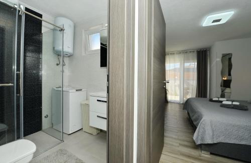 - une chambre avec une douche, un lit et une salle de bains dans l'établissement 2-Apartmans Villa PopandRock in Zadar, à Zadar