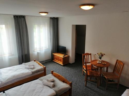 a hotel room with two beds and a table and chairs at Villa Bożena in Szklarska Poręba