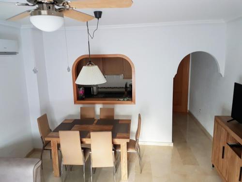 a dining room with a table and chairs and a ceiling fan at Townhouse Guardamar in Guardamar del Segura