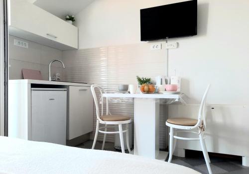 una pequeña cocina con mesa y 2 sillas en Studio Apartments Regina, en Bol