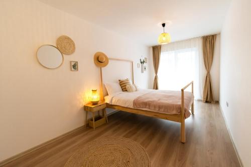 una camera da letto con un letto con una lampada e una finestra di Brown Bear Apt. BOHO Style Bedroom w/ City View & free Parking a Braşov