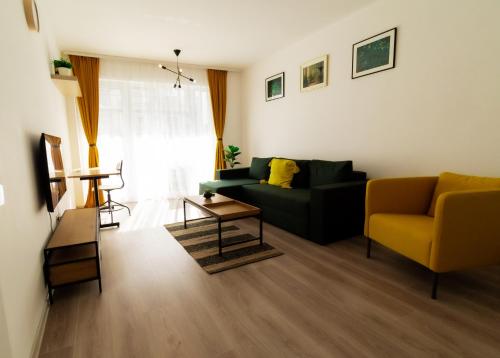 un soggiorno con divano verde e sedia gialla di Brown Bear Apt. BOHO Style Bedroom w/ City View & free Parking a Braşov