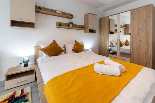 a bedroom with a large bed with a yellow blanket at Emma's Home in Braşov