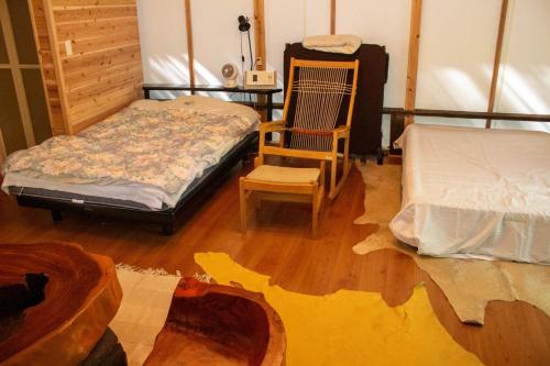 a living room with a bed and a chair at Glamping Himeshara - Vacation STAY 43046v in Kirishima