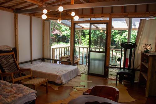 ein Schlafzimmer mit einem Bett und einem großen Fenster in der Unterkunft Glamping Himeshara - Vacation STAY 43046v in Kirishima