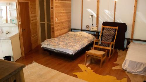 a bedroom with a bed and a chair in it at Glamping Himeshara - Vacation STAY 43046v in Kirishima