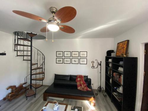 ein Wohnzimmer mit einem Sofa und einem Deckenventilator in der Unterkunft Casa do Beco B&B Douro - Guest House in Parambos