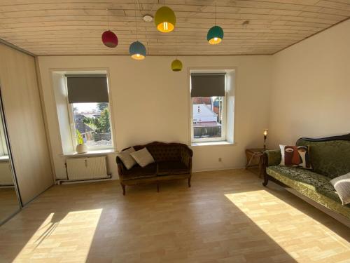a living room with a couch and two windows at N1 Apartment in the heart of Højer in Højer
