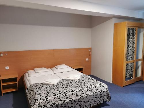 1 dormitorio con cama y cabecero de madera en Ośrodek Natura, en Pokrzywna