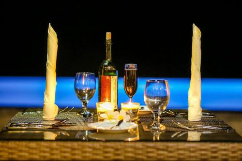 a table with wine glasses and a bottle of wine at Huluganga Ridge, Kandy in Kandy