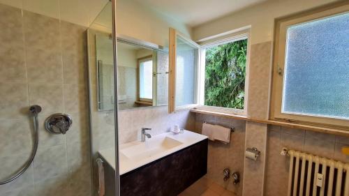 Un baño con lavabo, ducha y espejo. en Residence Atlantic, en Merano