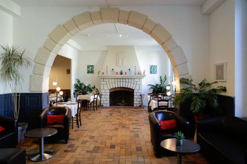 a restaurant with a fireplace and tables and chairs at Hotel Toppin in Cavaillon