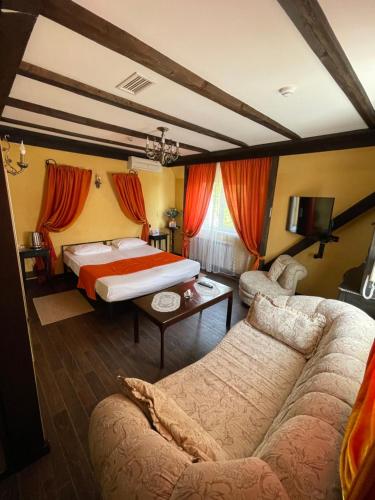 スタヴロポリにあるDisayn Hotel Shampanのベッドとソファ付きのホテルルーム