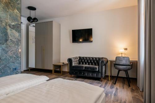 a bedroom with a bed and a chair and a desk at Dvorec Gregorčič in Smarjeske Toplice