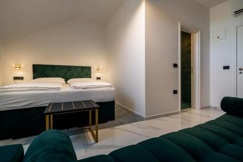 a bedroom with a bed and a couch at Dvorec Gregorčič in Smarjeske Toplice