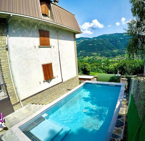 una gran piscina azul junto a un edificio en Grima appartaments en Rota d'Imagna