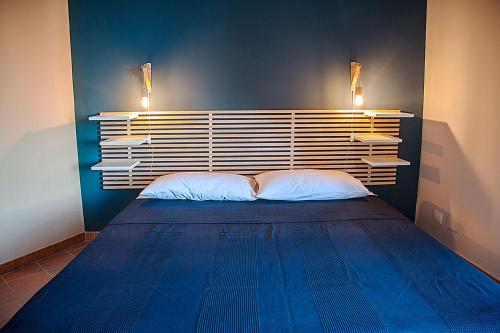 a bedroom with a large blue bed with two pillows at Casa Duci in Agrigento