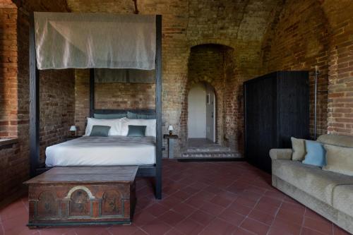 a bedroom with a canopy bed and a couch at Rocca di Arignano in Arignano