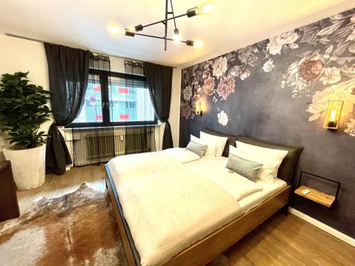 a bedroom with a bed with a floral wall at Boutique Apartment am Bahnhof in Freiburg im Breisgau