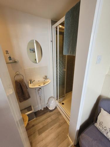 a small bathroom with a sink and a shower at Lyndale Guest House in Weymouth