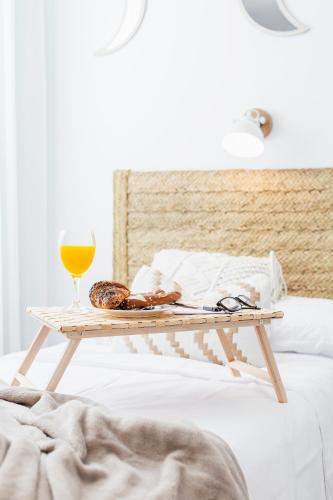 a coffee table with a glass of orange juice and a tray of food at Apartamentos Martalia Nerja in Torrox